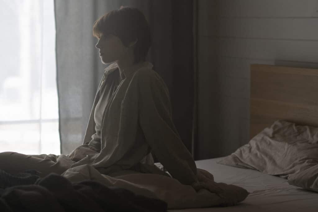 medium shot lonely woman sitting bed