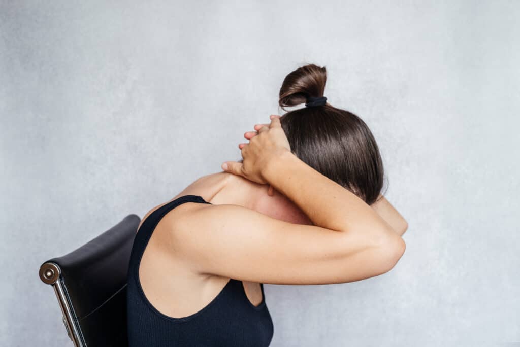 a woman doing the mckenzie method exercise for the neck, neck pain relief exercises