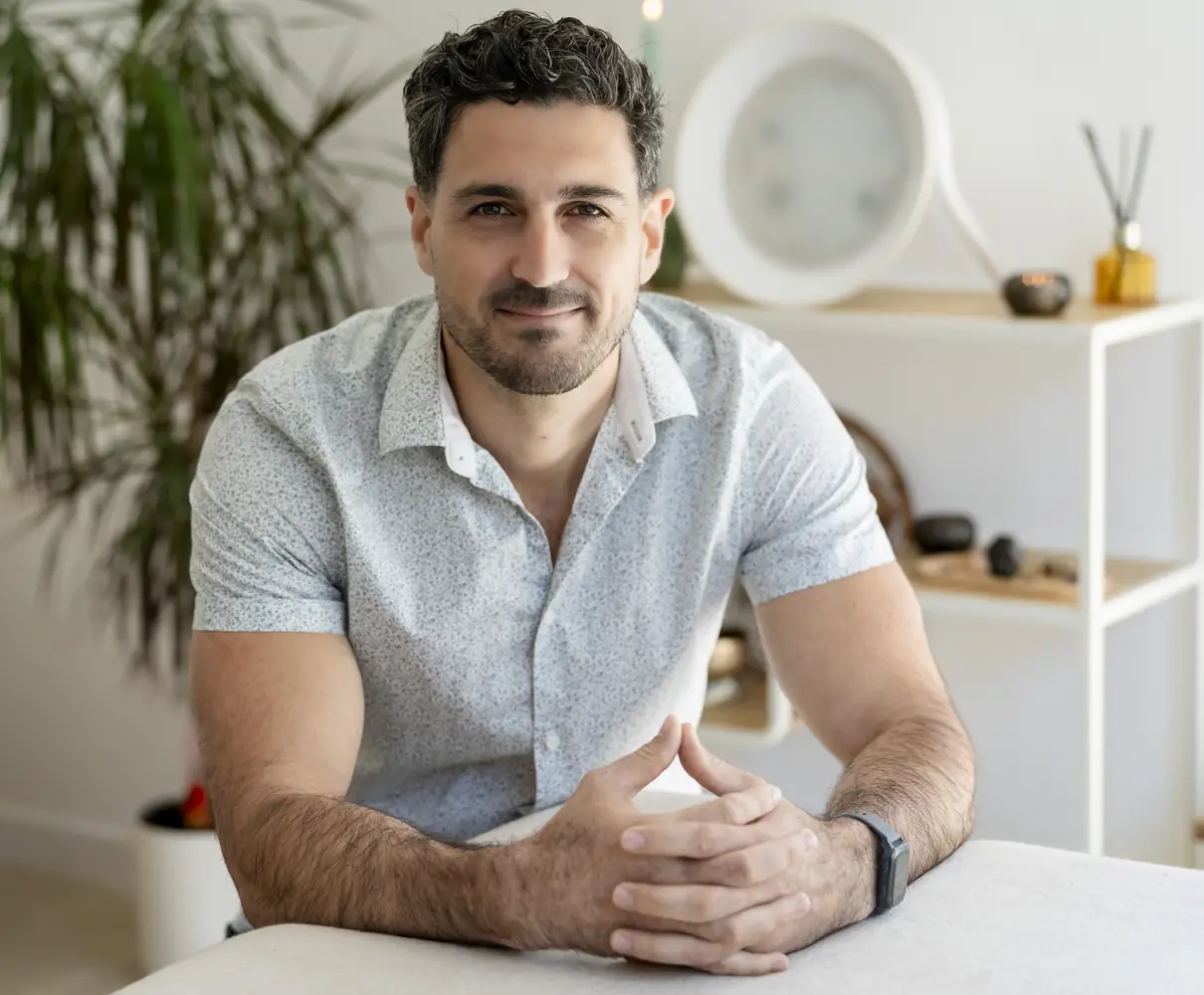 Romain Sol assis à la table d'échange de son cabinet, avant le soin